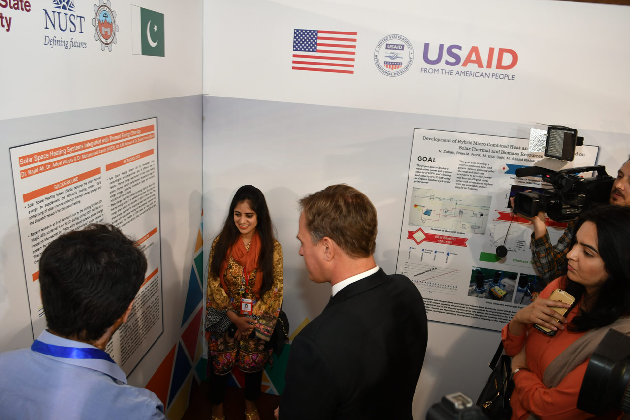 Fareeha Ahmad, a student from NUST discusses the Solar Space Heating Systems Integrated with Thermal Energy Storage joint research project with Dr. Christopher Steel, the USAID/Pakistan Education Director, at the first USPCASE Research Expo.